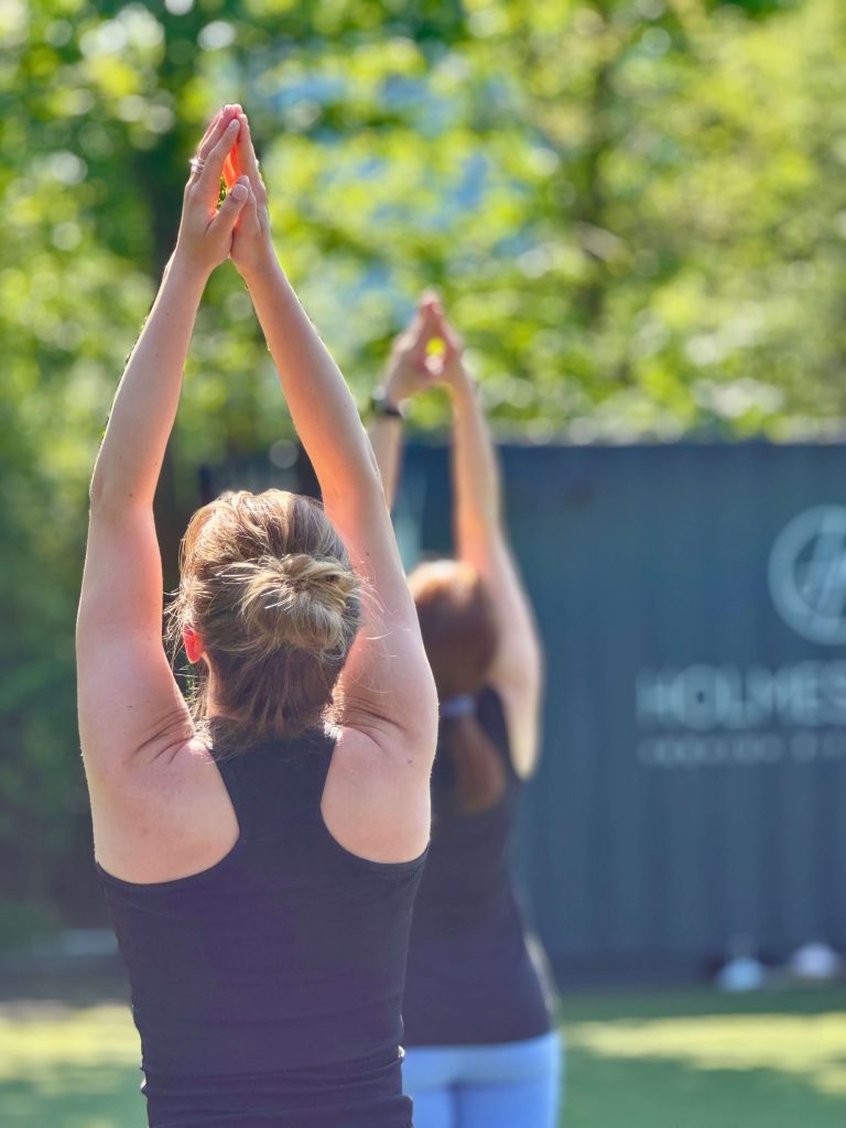 Teilnehmer beim Outdoor -Vinyasa-Yoga im Fitness Garden des Holmes Place Düsseldorf am Seestern - Yoga unter freiem Himmel bei Sonnenschein